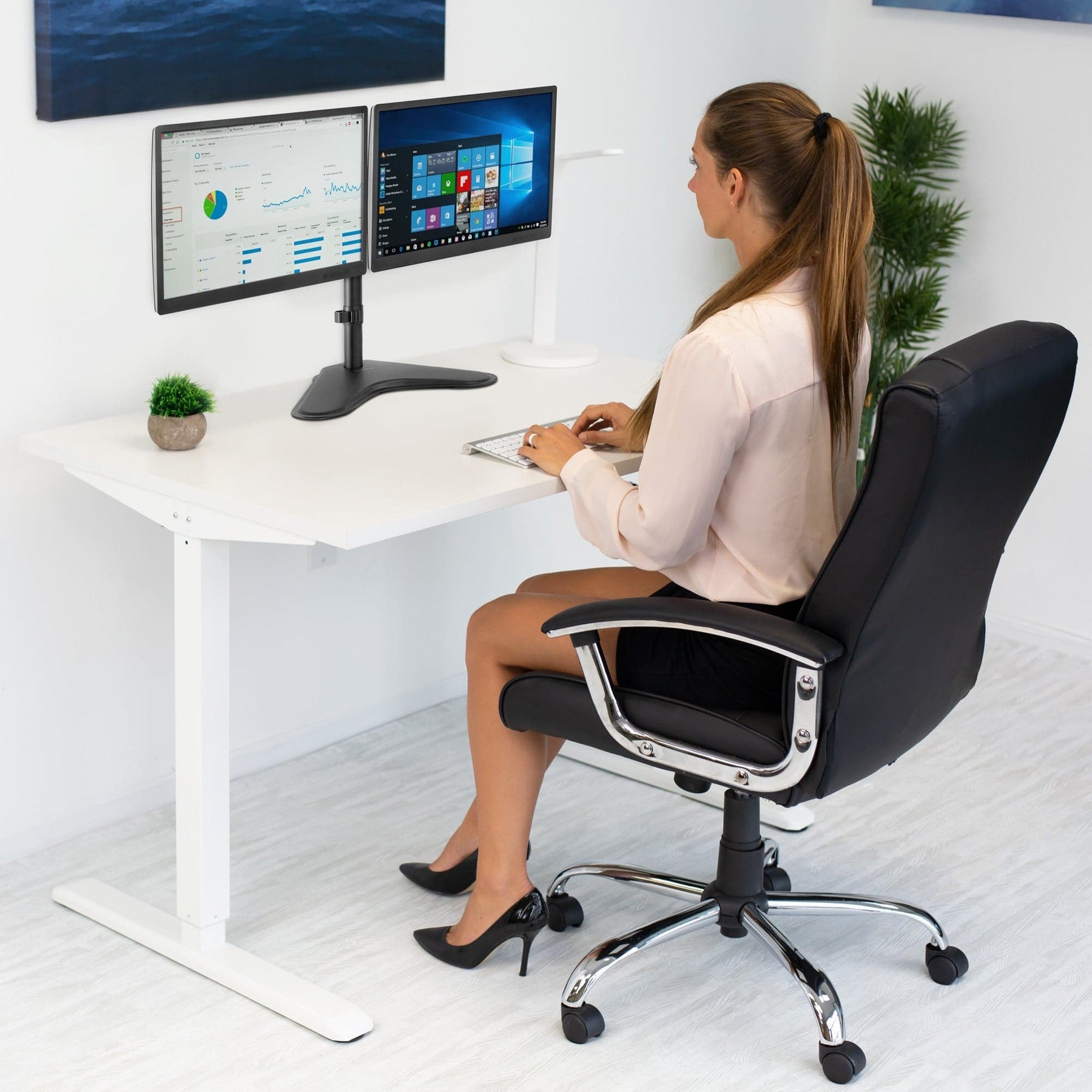 woman at desk with dual monitors